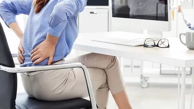Vrouw zit in een stoel achter haar bureau