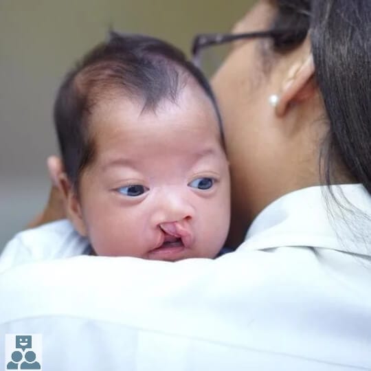 De bevalling, baby leunt met het hoofdje op een schouder van een vrouw.